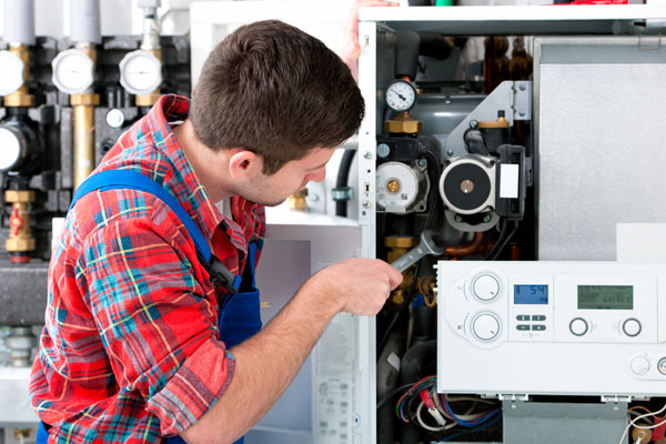 HVAC technician inspecting and repairing boiler controls in Provo