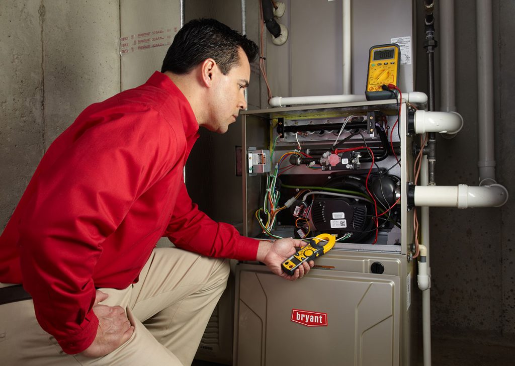 HVAC technician repairing an indoor furnace in Provo