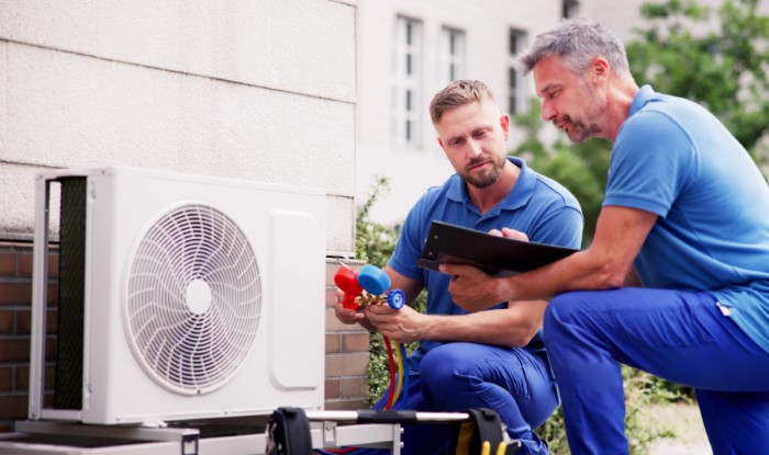 HVAC technicians installing an outdoor air conditioning unit in Provo
