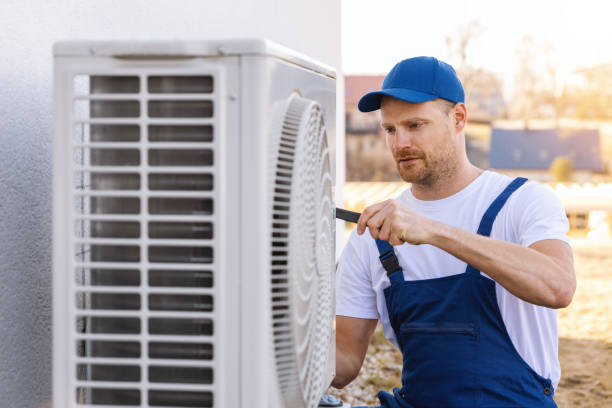 HVAC technician servicing an outdoor air conditioning unit in Provo
