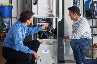 65df8c11f3e4c468cbd351a5_furnace repair vs replacement – Copy HVAC technician explaining furnace repair and maintenance to a homeowner in Provo, UT