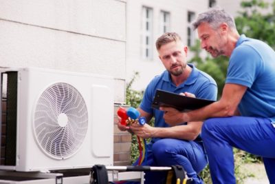 ac-installation-in-claremont-ca HVAC technicians reviewing an outdoor air conditioning unit in Provo, UT