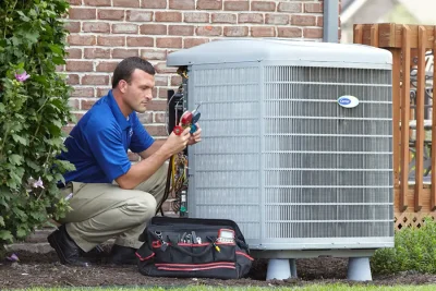 design-air-heating-and-air-conditioning-decatur-il-05 – Copy HVAC technician inspecting an outdoor air conditioning unit in Provo, UT